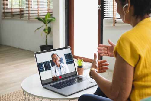 Image depicting telemedicine with doctor treating a patient