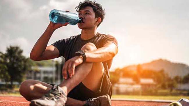 Wellness research: Runner on track drinking water
