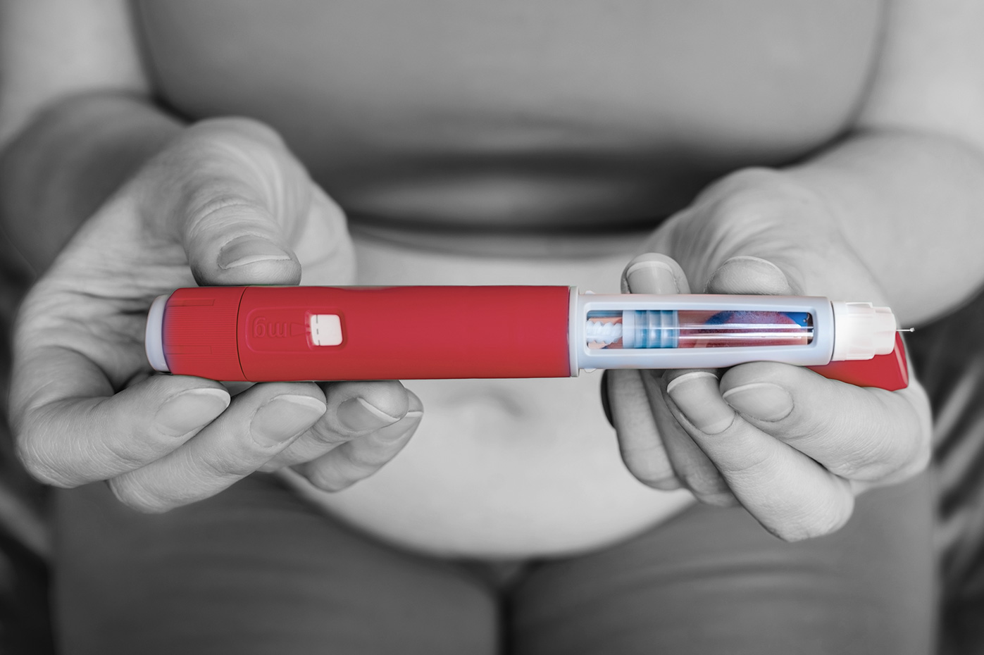 A woman holding a GLP-1 pen