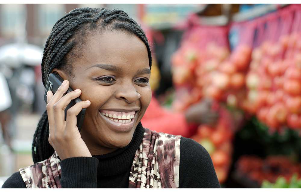 An African woman on a smartphone illustrates the opportunity of microinsurance