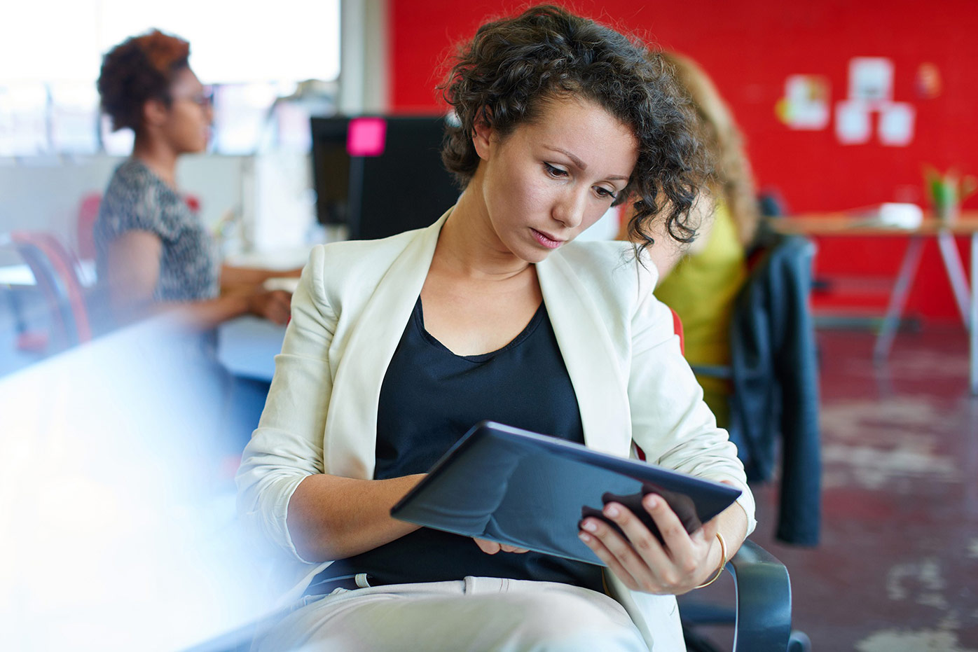 Woman sitting and looking at a tablet