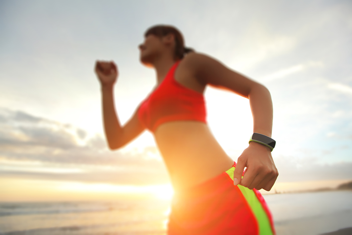 Running woman with wearables and wellness