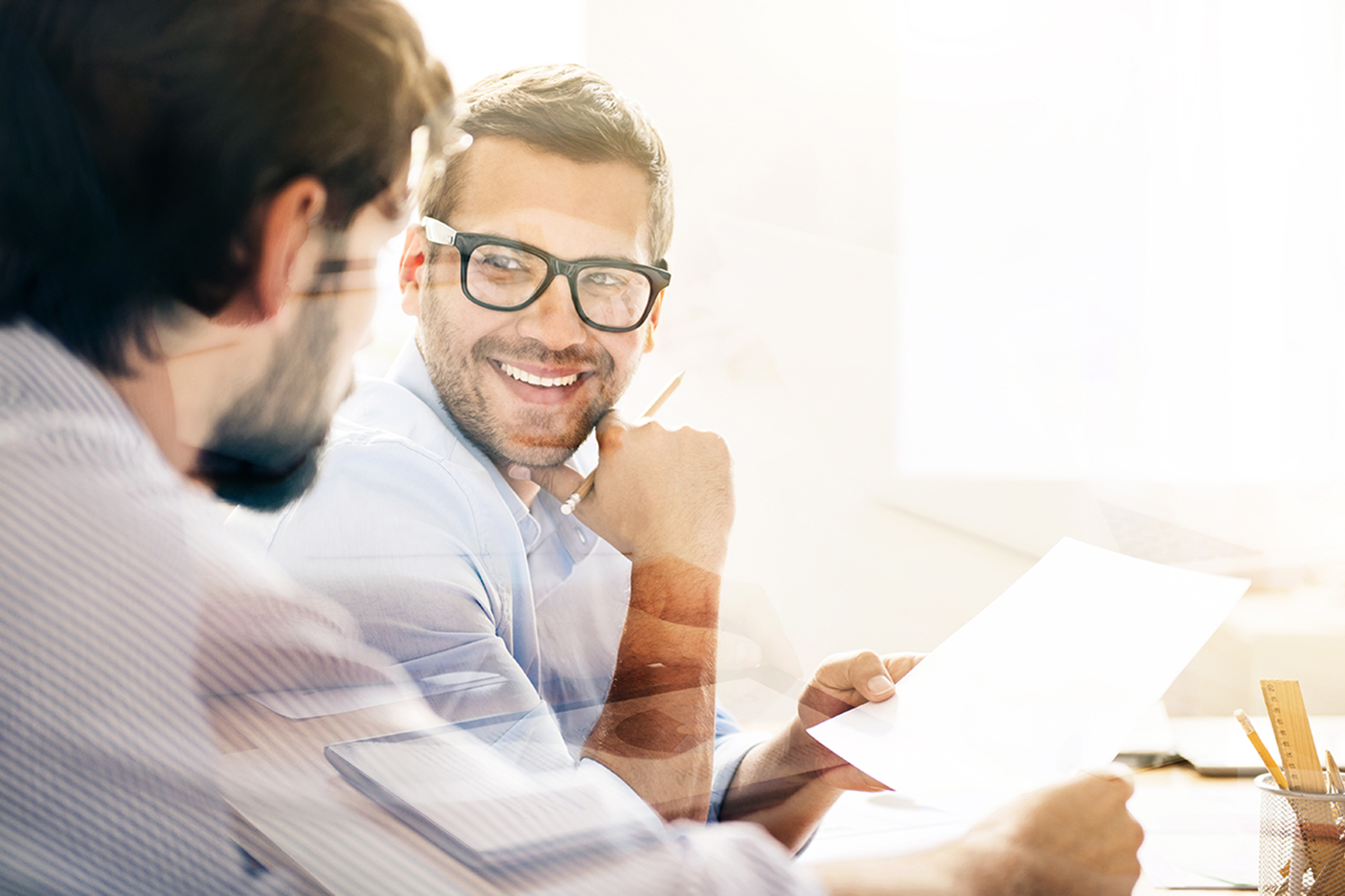 Lens flare obscures a candid conversation between two businessmen