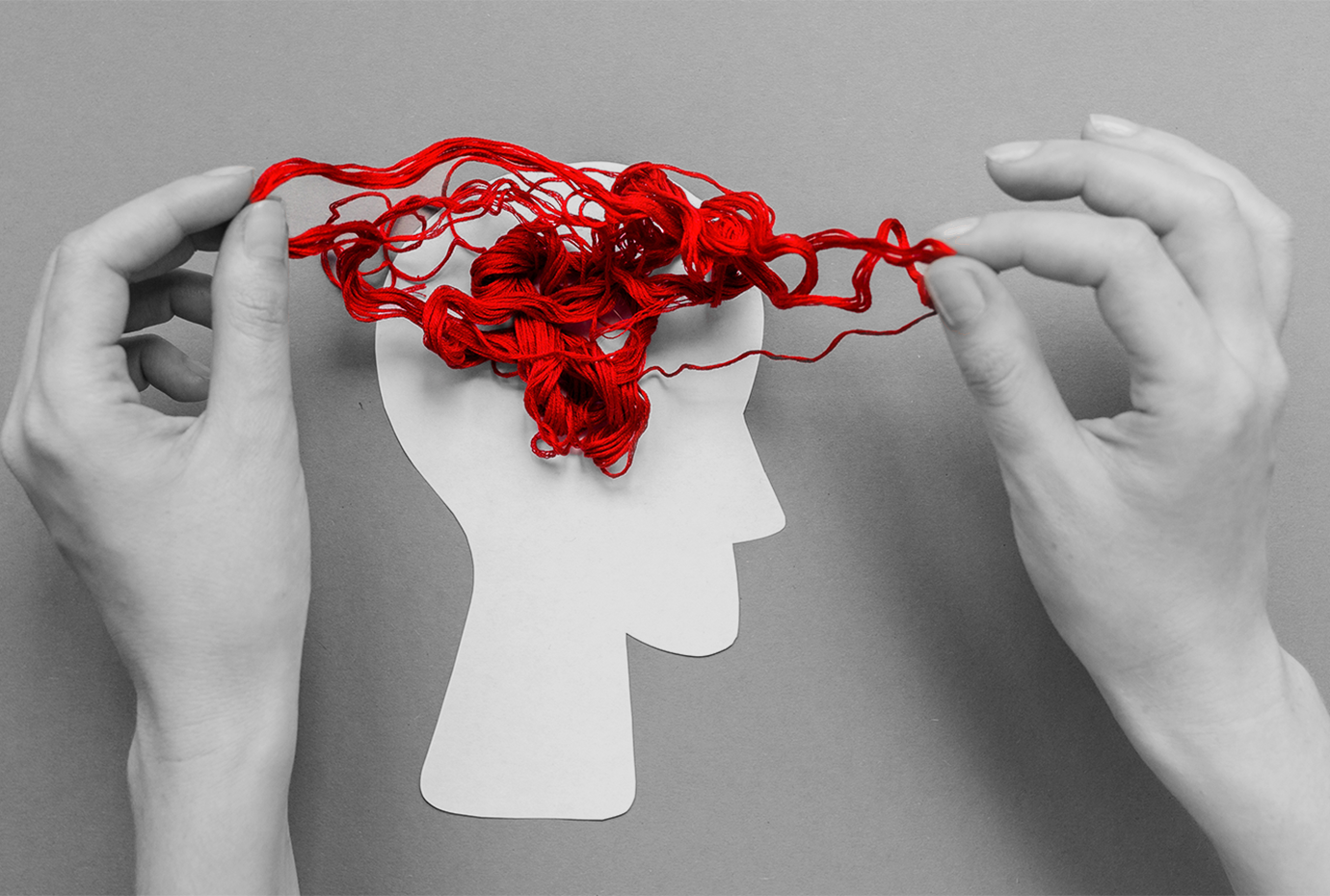 A tangled string in a cutout of a human head