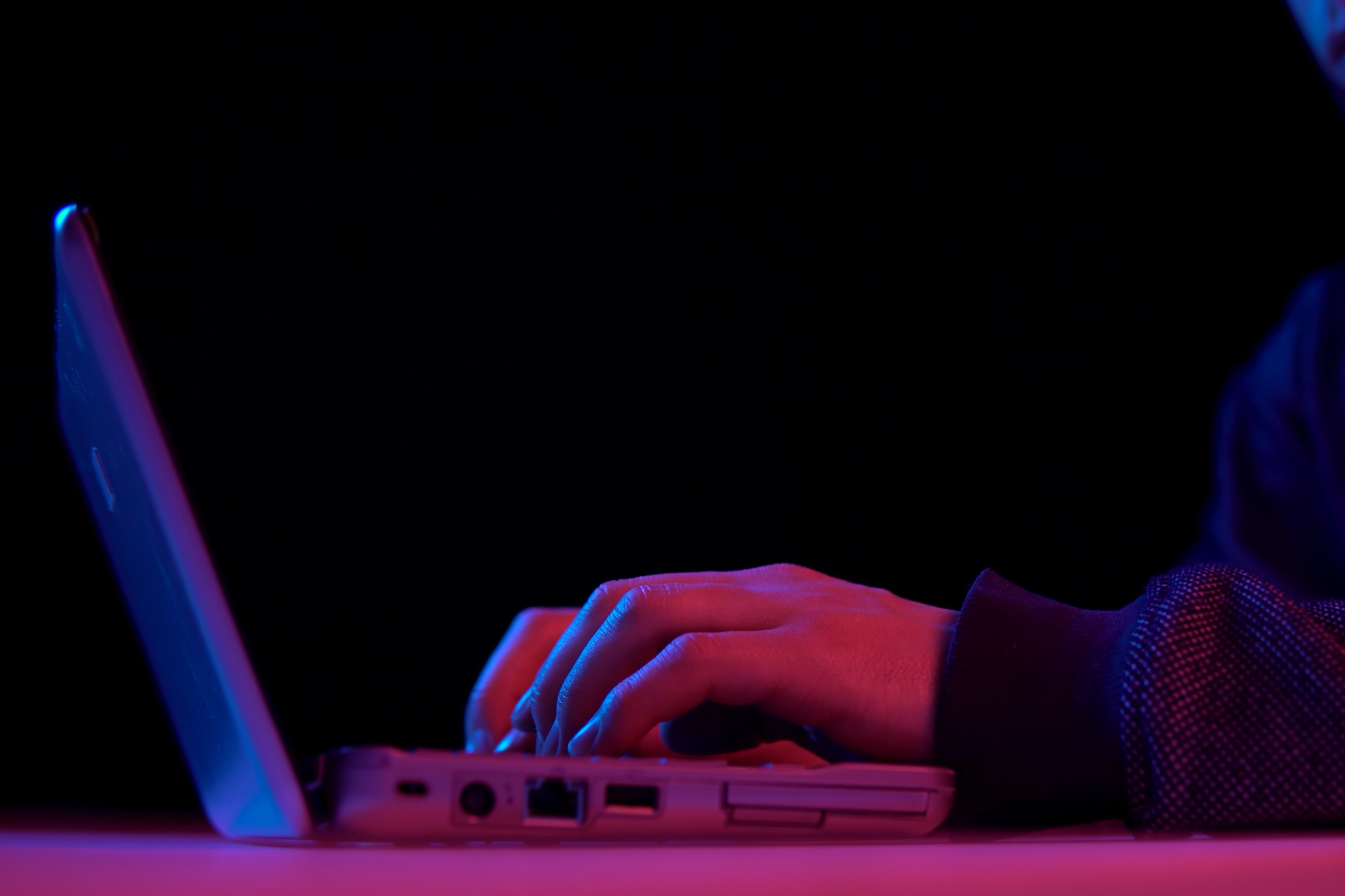 Man in dim light typing on computer