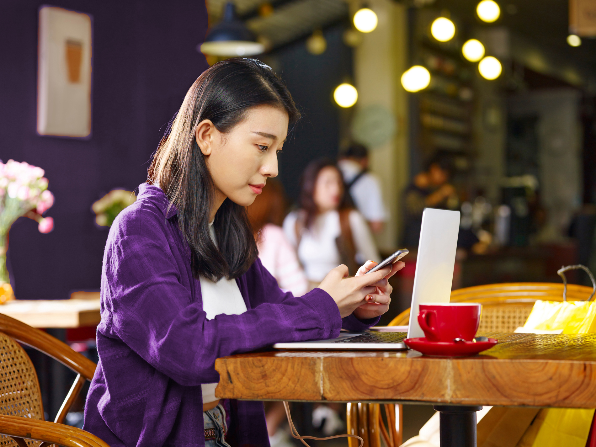 Woman working in a coffee shop, on her phone