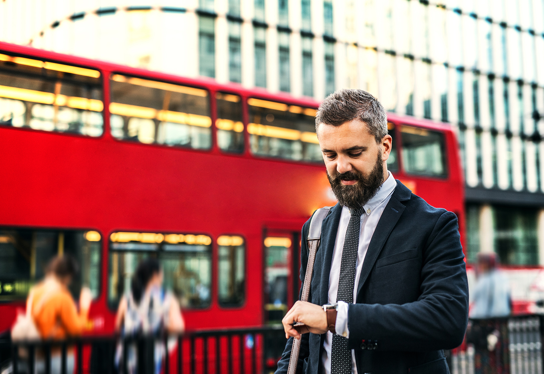 Funded-Re-UK-Japan-Jamie-Campbell-1026-P3 Man in suit in the UK looking at his watch while a double decker bus goes by