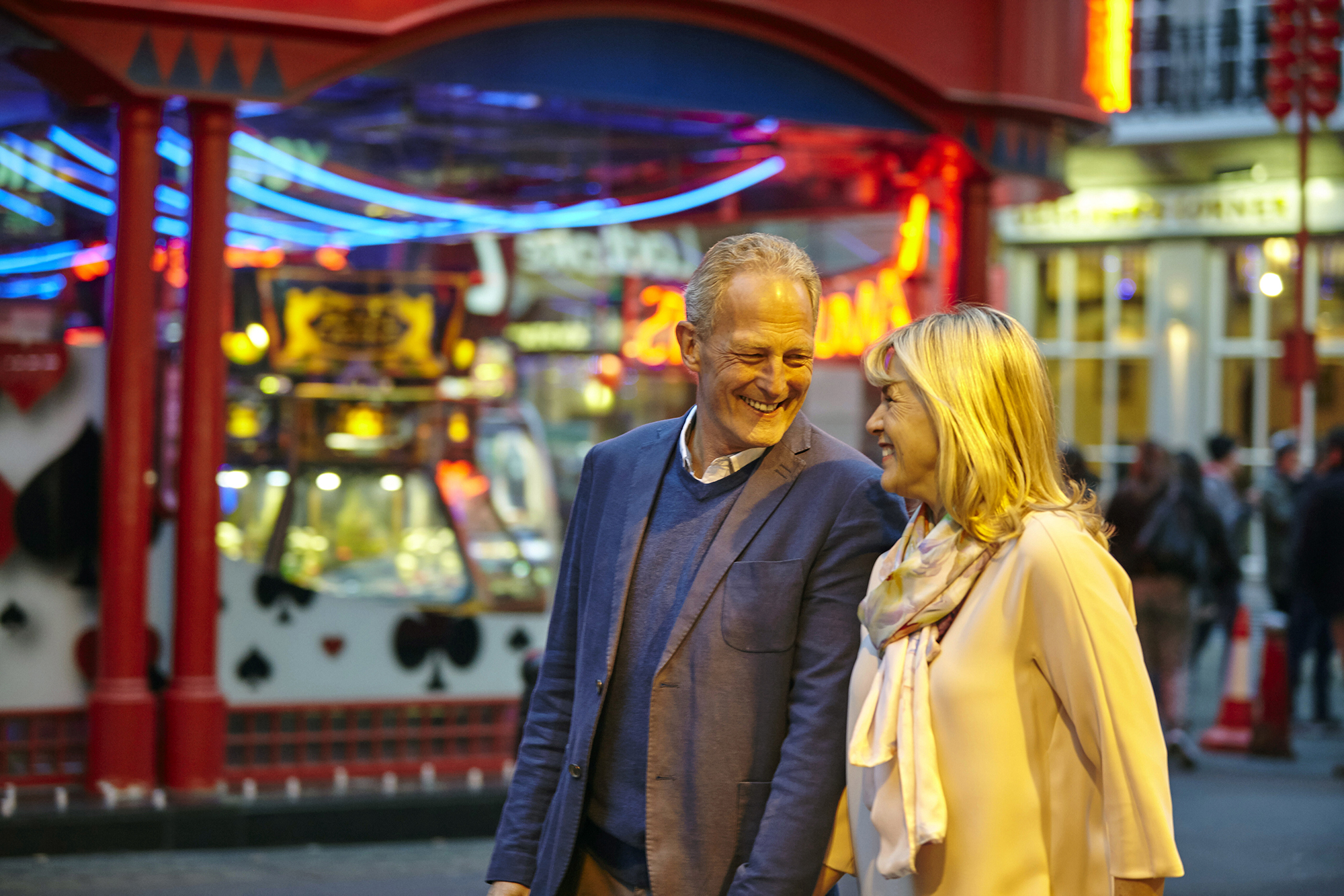 A middle-aged man and woman walking through a carnival