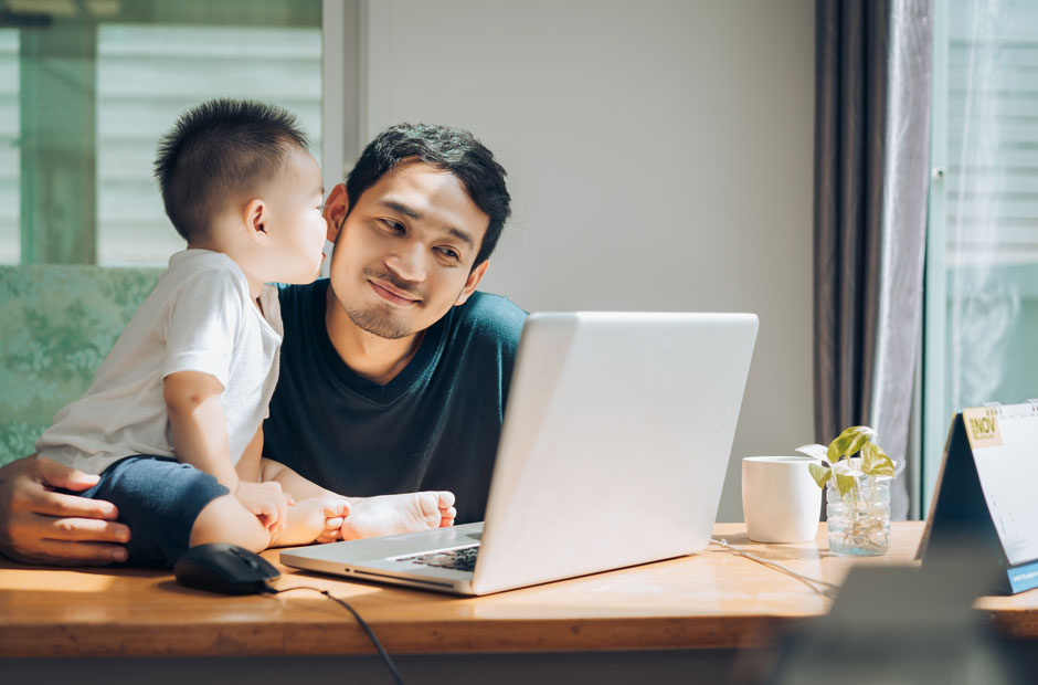 Baby and Dad embrace over a computer