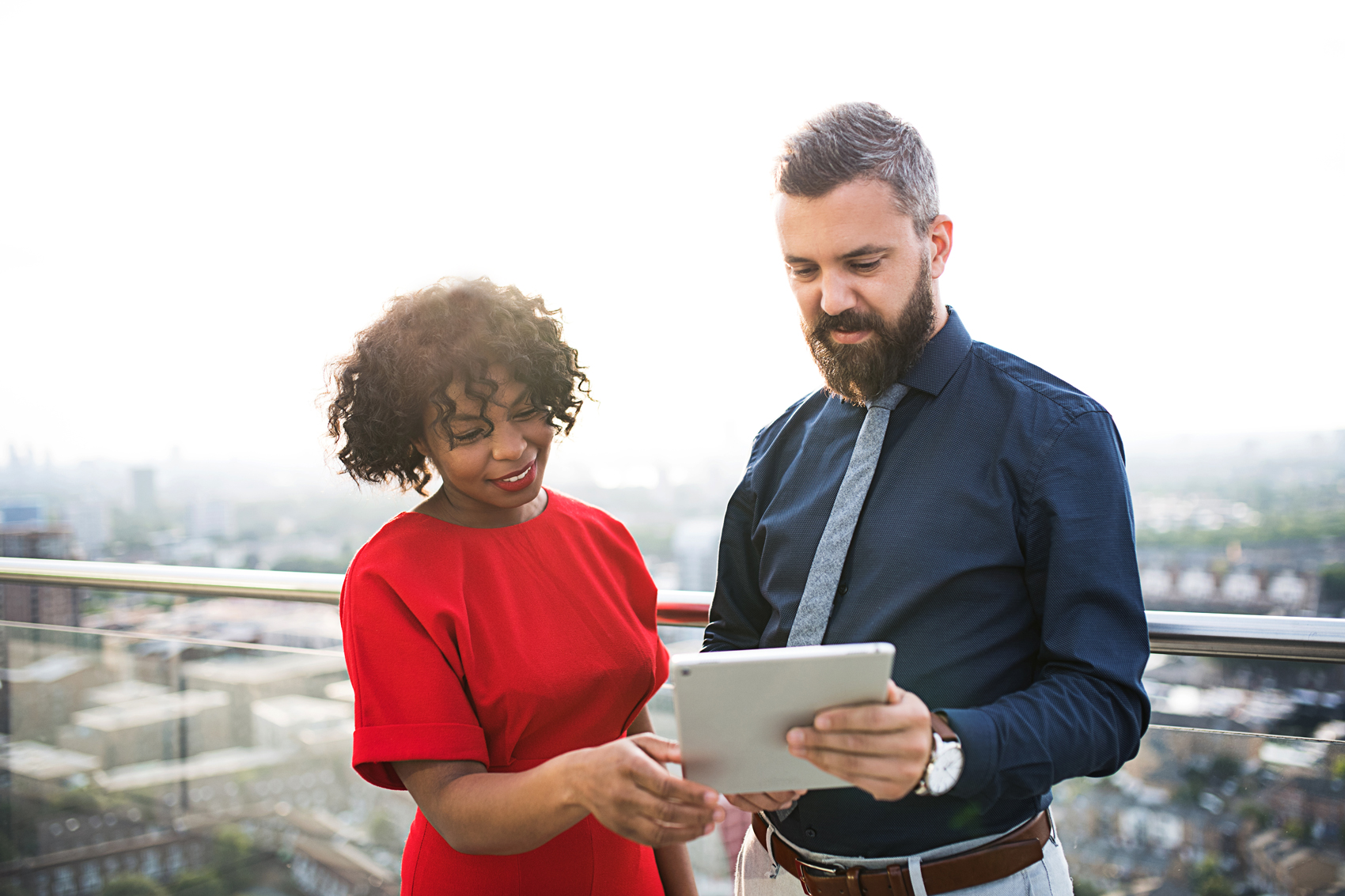 A pair of colleagues review a tablet together. 