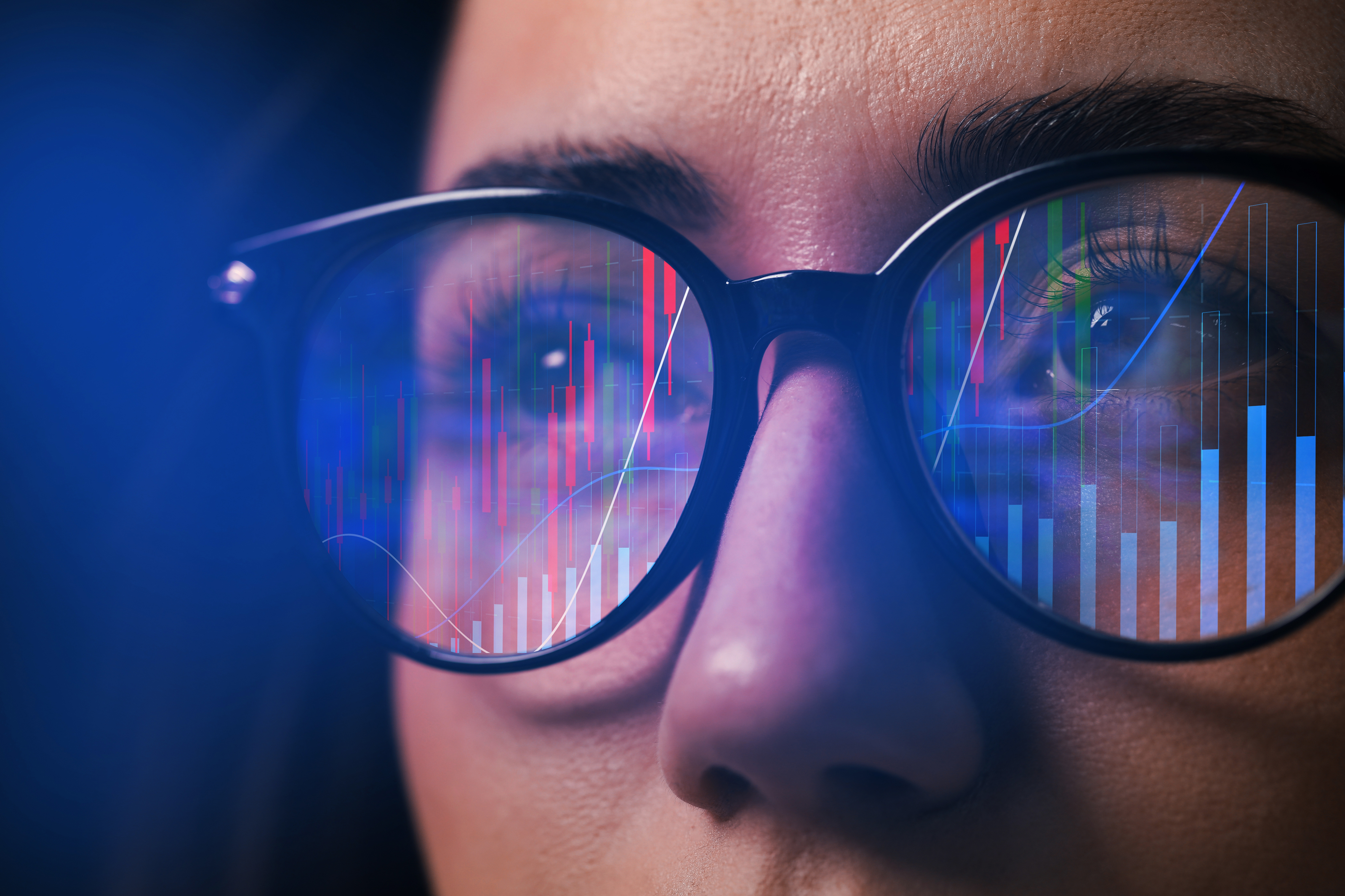 Digital Bar Charts Reflecting Off of a Women's Glasses