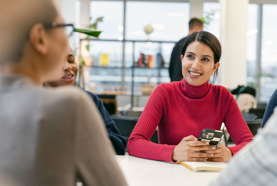 A young woman looks ahead, immersed in a conversation around underwriting innovation.