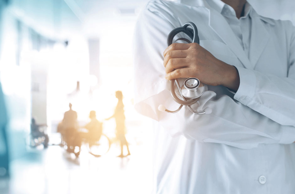 A physician is foregrounded supported by a group of businesspeople in the background