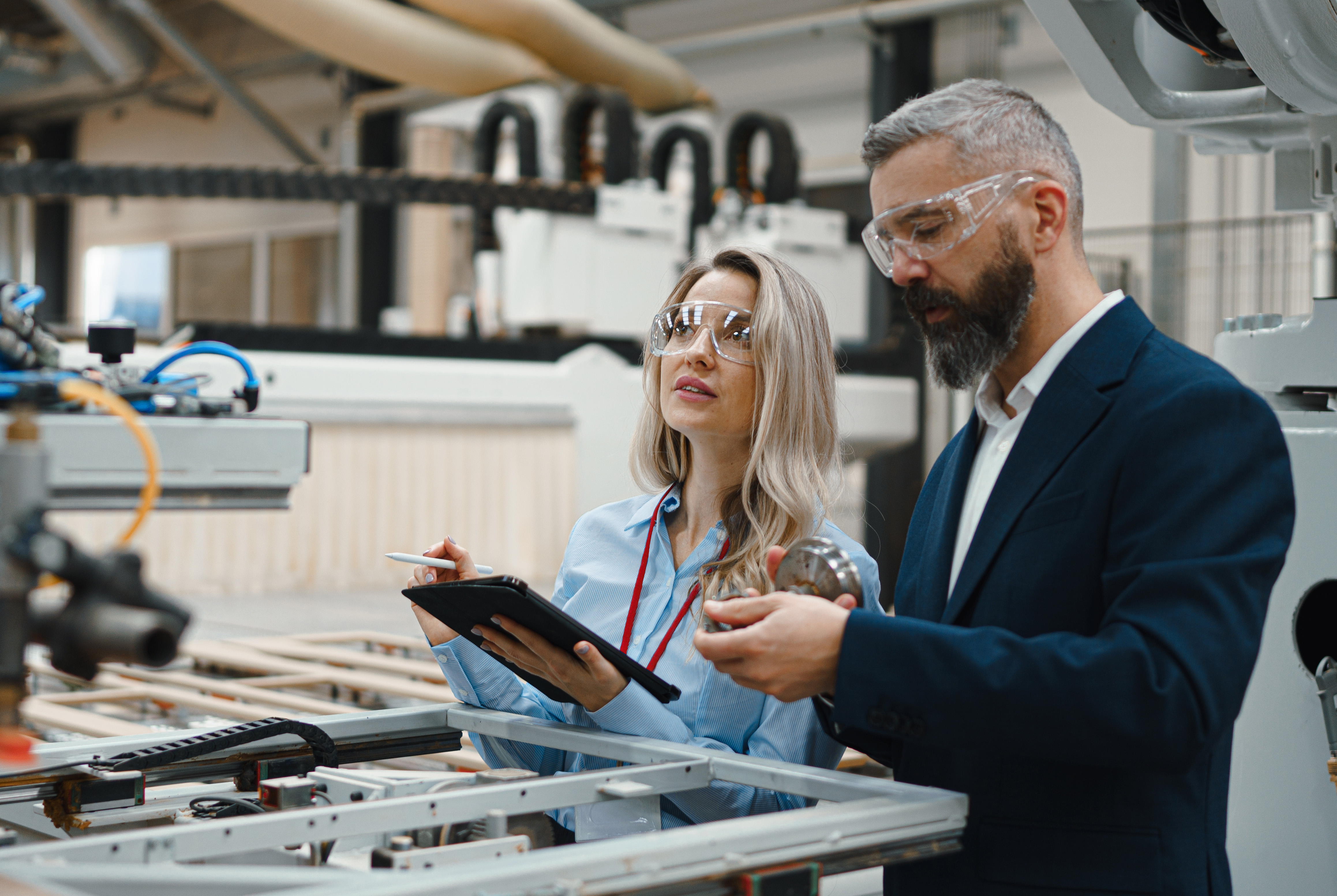 Man and woman going through a checklist at a manufacturing plant Man and woman going through a checklist at a manufacturing plant