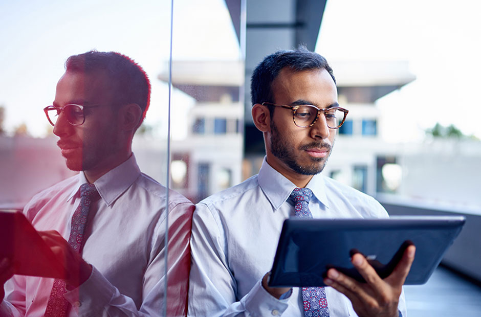 Man-working-on-ipad, looking intently at analytics