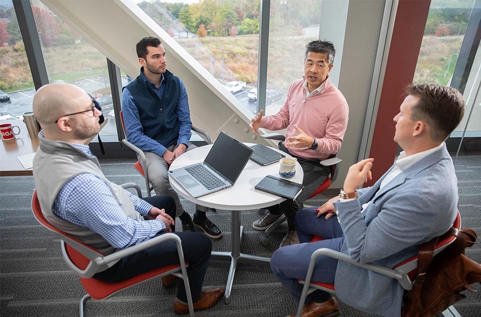 Private Debt and Equity Team Meeting at RGA Headquarters Office with Large Window in the Background