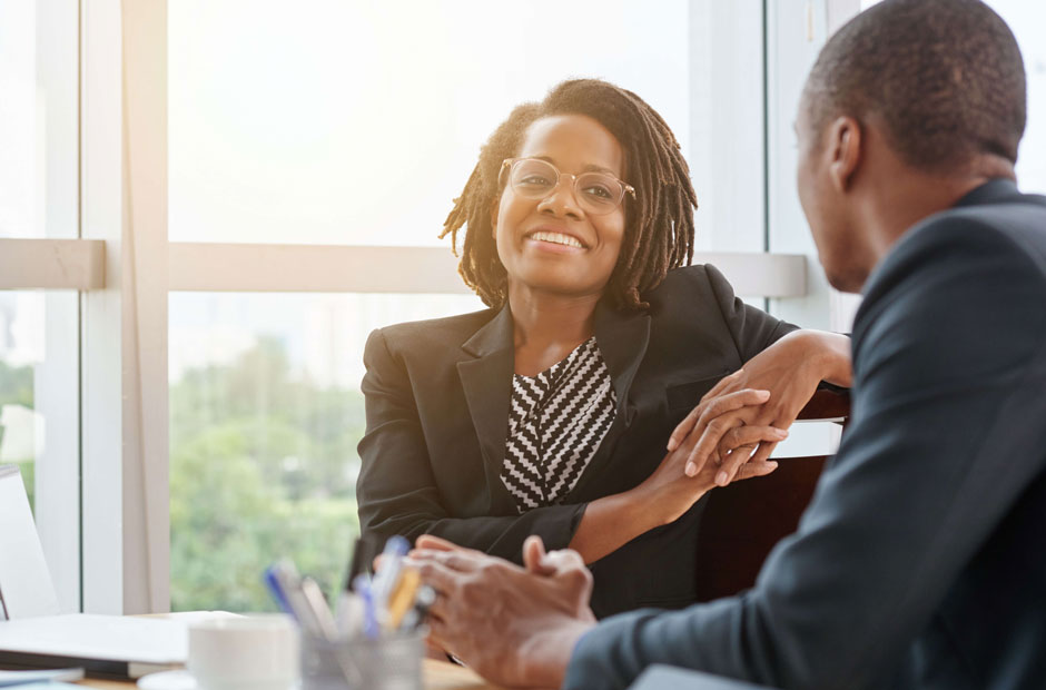 A young woman discusses reinsurance with a peer