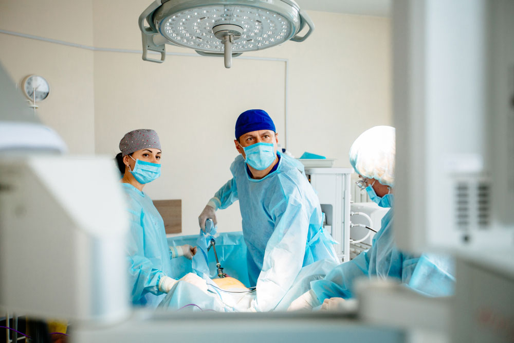 A surgeon looks up intently at a screen during an operation