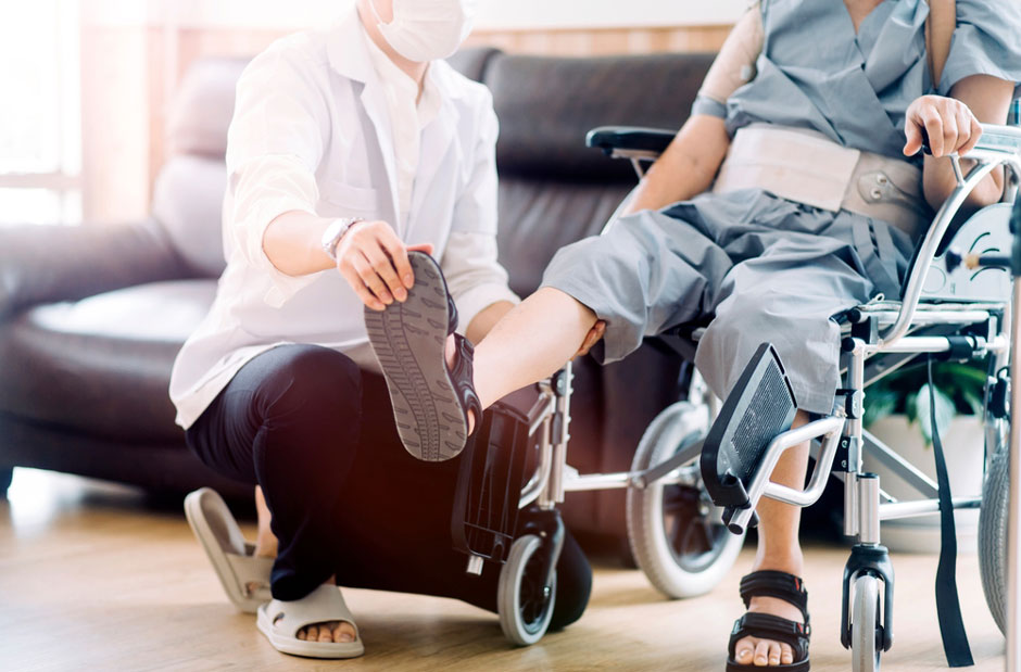 A physical therapist works with a disabled individual to recovery