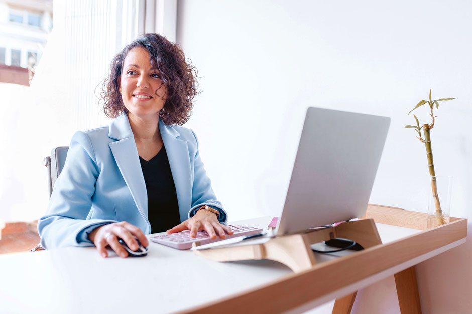 A professional woman looks up hopefully from her desk after qualifying for continuing education credits