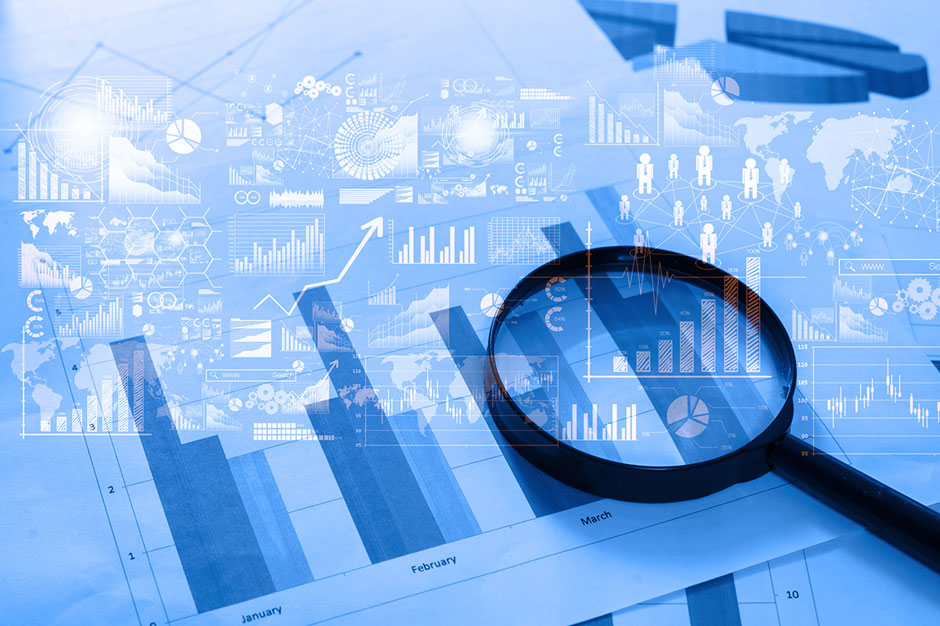 A magnifying glass sits atop a spreadsheet