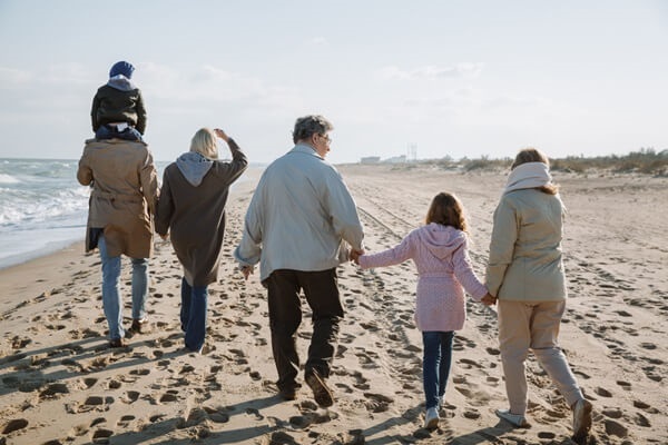 A family walks along the beach