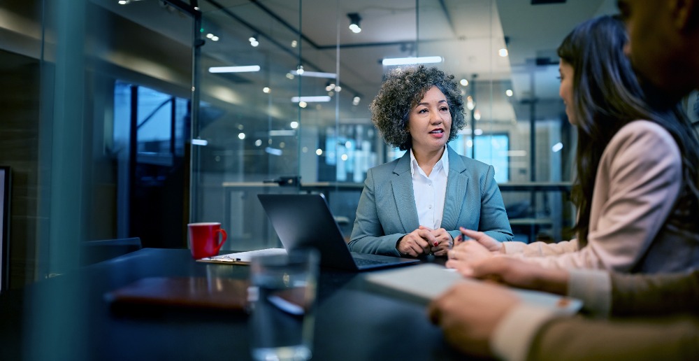 Two Businesswomen in a Meeting in a Glass Huddle Room