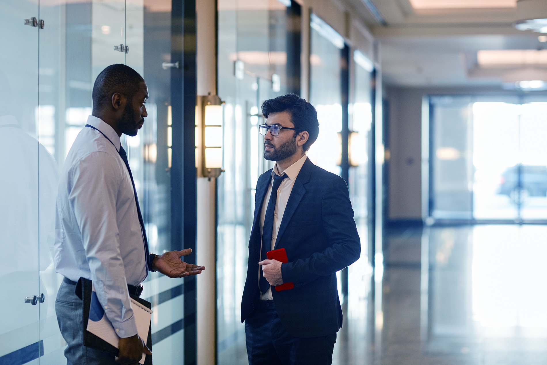 Two Businesspeople in Conversation in the Hallway of their Office