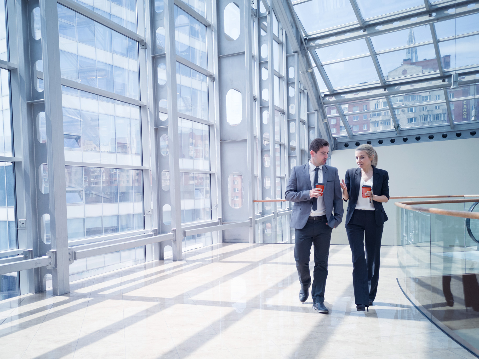 Two Businesspeople in Discussion While Walking in an Office