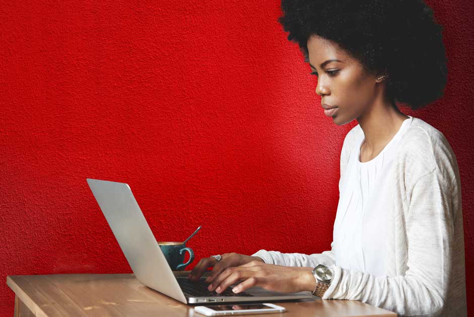 A woman types on a laptop, completing claims training