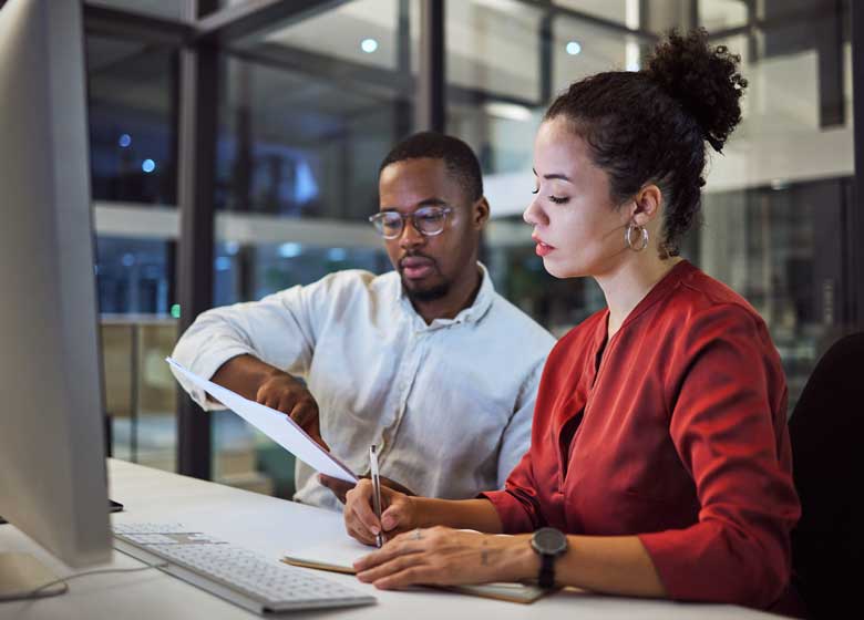 A pair of employees review analytics around an insurance operation