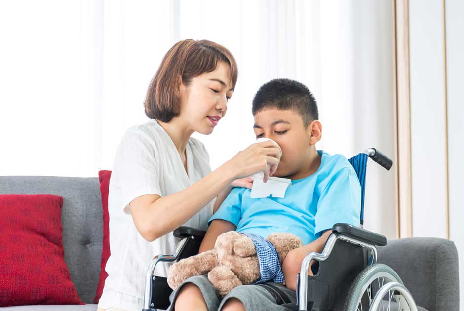 A caregiver assists a wheelchair-bound child