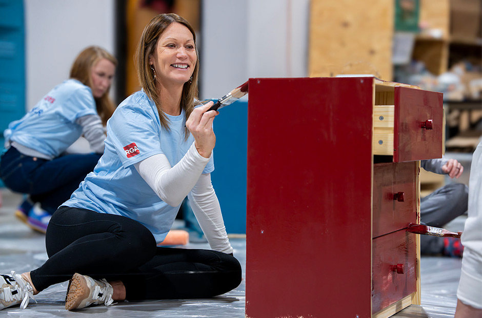RGA employee painting a dresser at the Home Sweet Home project