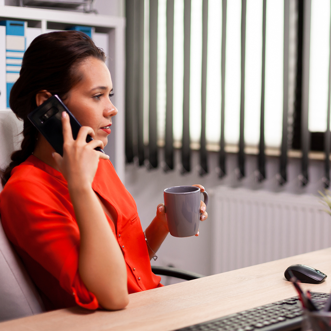 A woman on the phone sipping coffee
