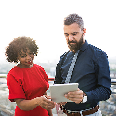 A woman and a man looking at a tablet together