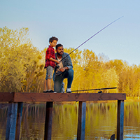 Father and son fishing on a dock