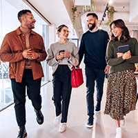 Four people walking and laughing