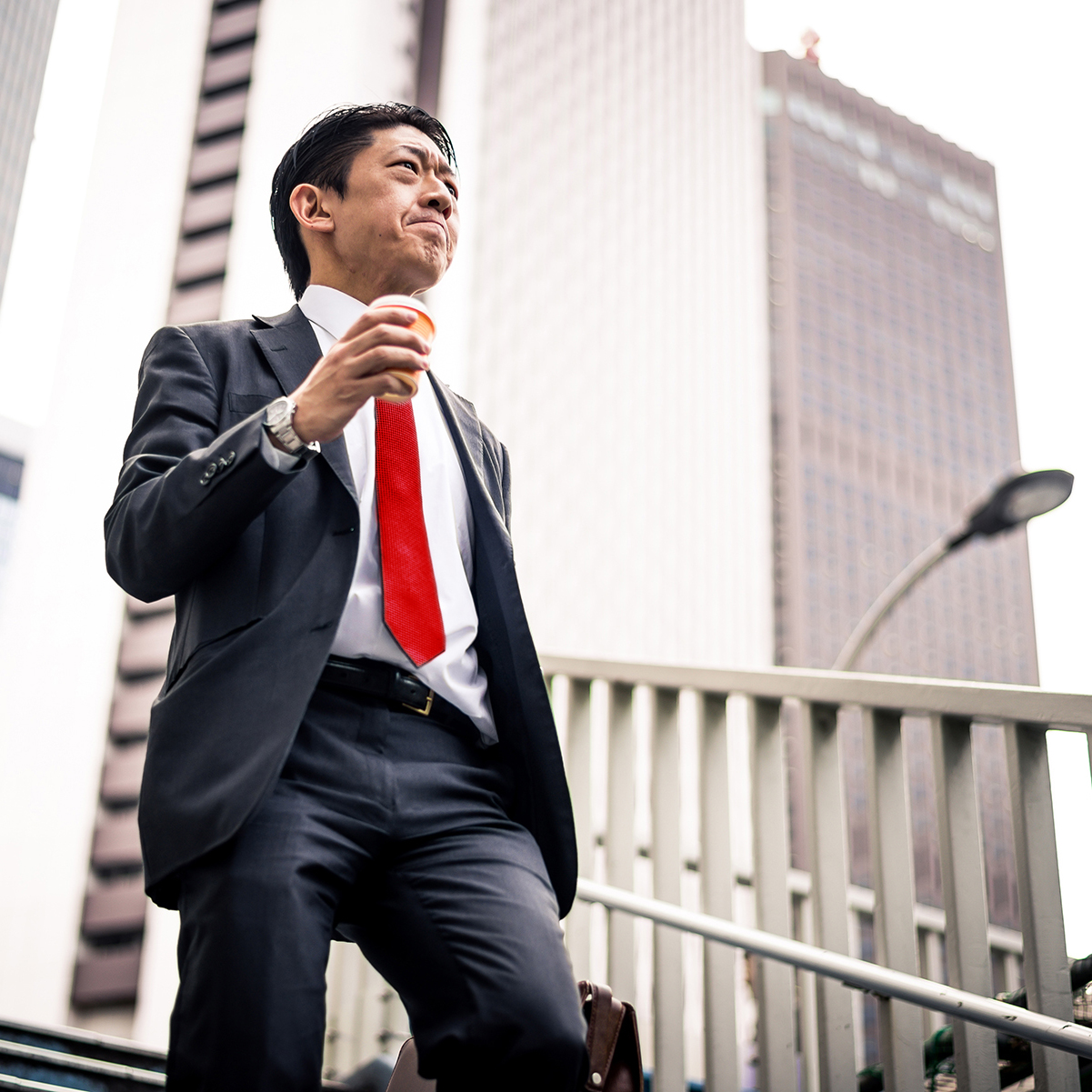 Man in a business suit coming down the stairs outside