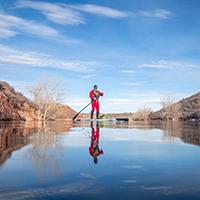 Man standing on paddleboard in lake