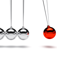 close-up of newtons cradle in motion with red and silver balls