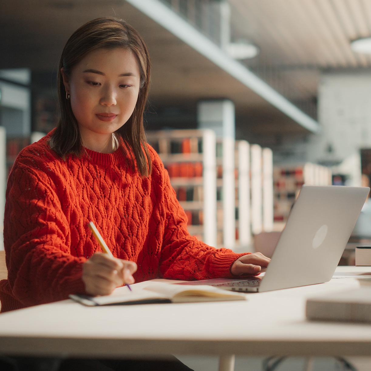 Woman on a laptop, taking notes