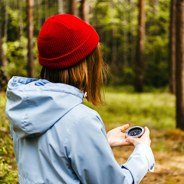 Woman in the woods with a compass