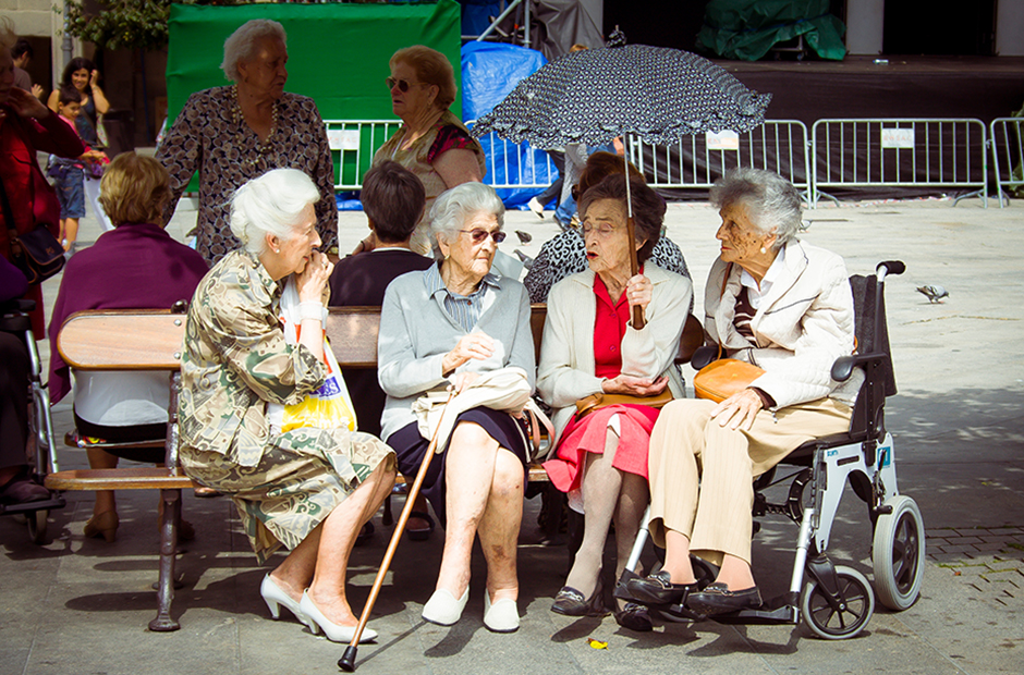 A cluster of elderly ladies meet in a park