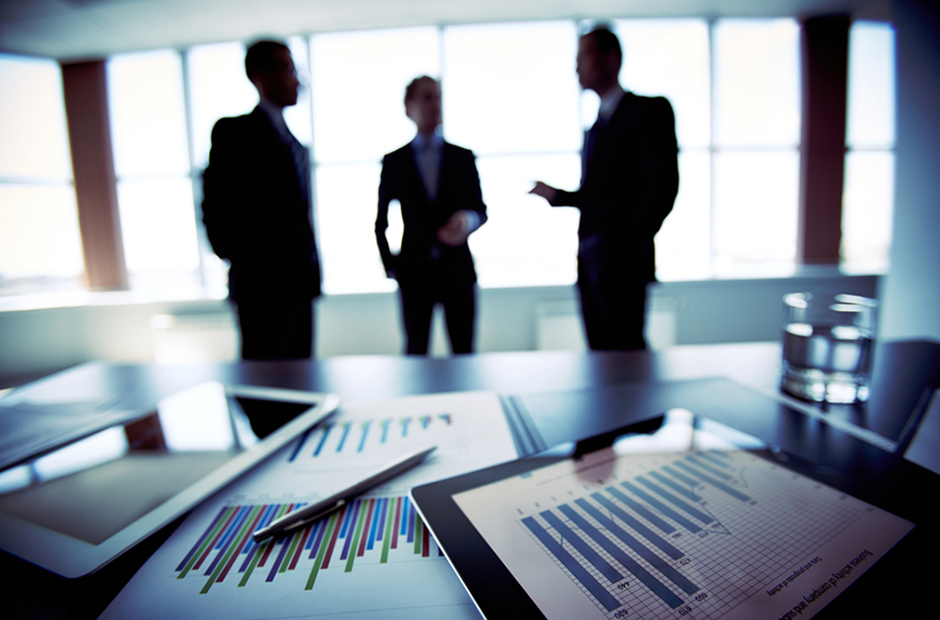 Boardroom meeting with spreadsheets and numbers