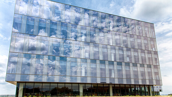 Clouds float across the glass facade of RGA's headquarters building